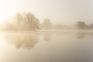 Obraz na płótnie Canvas Foggy early morning on a lake.