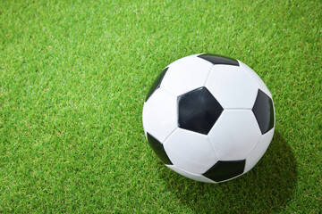 Fototapeta na wymiar Soccer ball on the grass top view close up
