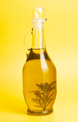 Jug with olive oil, on yellow background.