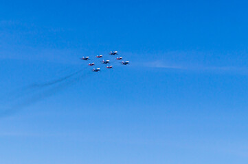 Aerobatic group of planes and blue sky. Performance in the sky and demonstration of aerobatics. Spatial maneuvering of the aircraft. The flight of the plane.