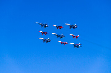 Aerobatic group of planes and blue sky. Performance in the sky and demonstration of aerobatics. Spatial maneuvering of the aircraft. The flight of the plane.