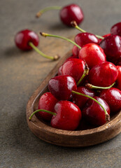 Close up of some fresh sweet cherries on wooden plate