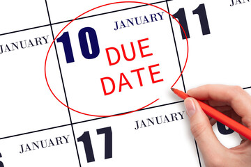 Hand writing text DUE DATE on calendar date January 10 and circling it. Payment due date