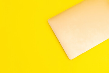 Laptop lies on a golden background