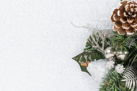 Background with a pine cone and silver green christmas decoration isolated on a silver background.