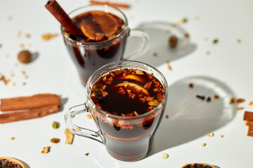 Cup with Christmas mulled red wine with spices and oranges on a white background hard light, traditional hot drink at Christmas, festive cocktail