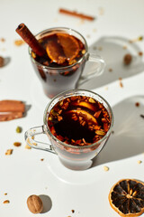 Cup with Christmas mulled red wine with spices and oranges on a white background hard light, traditional hot drink at Christmas, festive cocktail