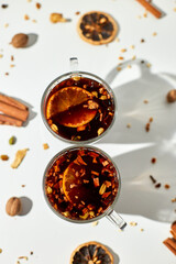 Cup with Christmas mulled red wine with spices and oranges on a white background hard light, traditional hot drink at Christmas, festive cocktail