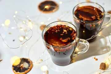 Cup with Christmas mulled red wine with spices and oranges on a white background hard light, traditional hot drink at Christmas, festive cocktail