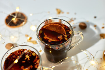 Cup with Christmas mulled red wine with spices and oranges on a white background hard light,...