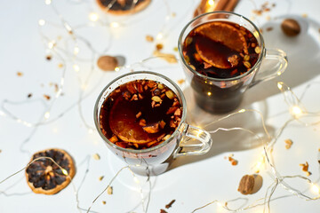 Cup with Christmas mulled red wine with spices and oranges on a white background hard light, traditional hot drink at Christmas, festive cocktail