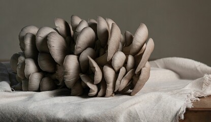 Closeup shot of gray oyster mushrooms on a white cloth placed on a wooden table