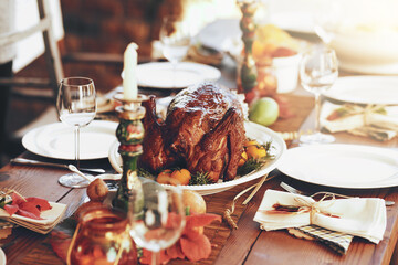 Thanksgiving, turkey and food with a roast meal on a dinner table for a celebration event or tradition. Christmas, chicken and lunch with a healthy diet on a wooden surface for the festive season