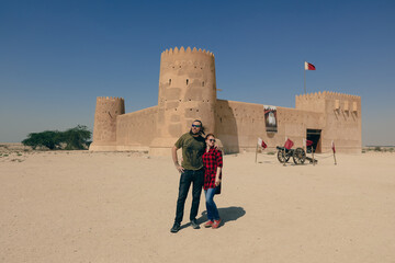 Happy Couple near the Al Zubara Fort, historic Qatari military fortress, in the ancient town of Zubarah, Qatar