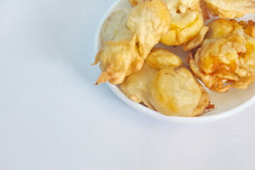 Indonesian style fried banana in a small bowl on a white background, traditional snacks