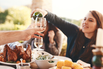Party, dinner and woman pouring wine in a wine glass to cheers at an outdoor celebration feast. Champagne, toast and girl serving a luxury alcohol drink at event in nature or backyard garden at home.