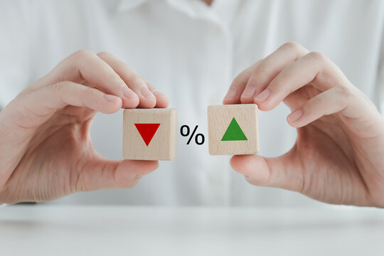 Percentage Sign And Hand Holding Wood Block With Direction Of Arrow That Going Down Or Up. Interest Rate Finance And Mortgage Rates Concept.  Business And Financial, Inflation, Sale Price, Loan, Tax.