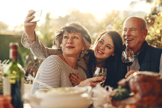 Family, phone selfie and happy thanksgiving, lunch and happy with wine, glass and social media photo in home. Senior mother, father and daughter smile, love and together for picture, alcohol and care