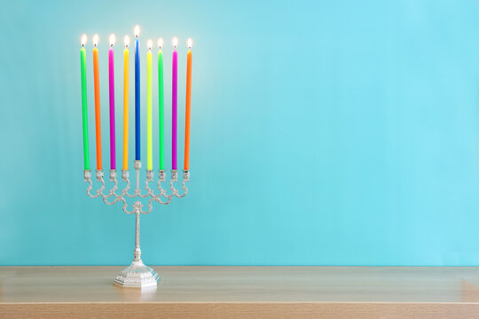 Image of jewish holiday Hanukkah with menorah (traditional candelabra) and colorful candles