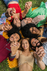 Close up multiracial group of young people with united hands lying