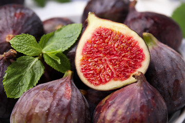 Tasty ripe figs and green mint leaves, closeup