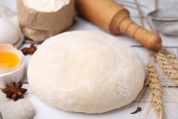 Fototapeta na wymiar Fresh dough and ingredients on white wooden table, closeup