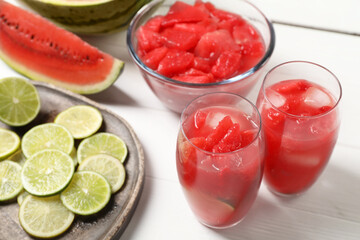 Fresh watermelon drink with lime and ingredients on white wooden table
