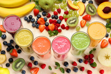 Composition with fresh colorful fruit smoothies and ingredients on beige table, above view