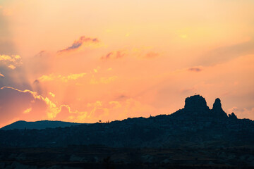 Stunning sunset behind the Uchisar Castle in Cappadocia. The Uchisar Castle is located in the town of Uchisar, and stands proudly as the highest point in Cappadocia. Goreme, central Antolia, Turkey.