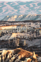 Stunning view of a person in the distance enjoying the view of the Cappadocia landscape during a beautiful sunrise. Goreme, central Antolia, Turkey.