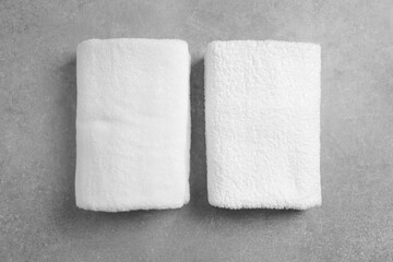 Soft folded towels on gray background, flat lay