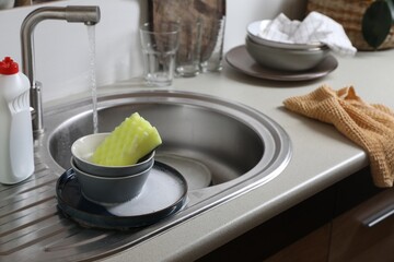 Bowls and sponge on kitchen sink. Washing dishes