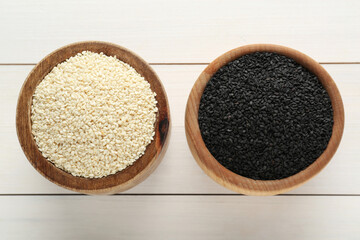 Different sesame seeds on white wooden table, flat lay