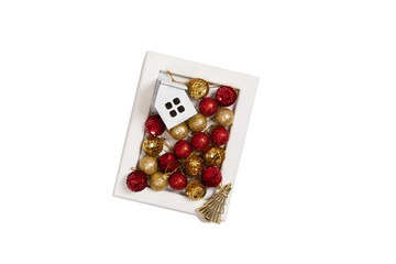 Wooden frame with christmas decoration of red and golden ornaments, golden tree and wooden house