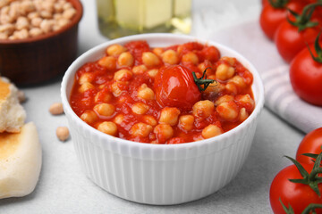 Delicious chickpea curry in bowl on light gray table, closeup