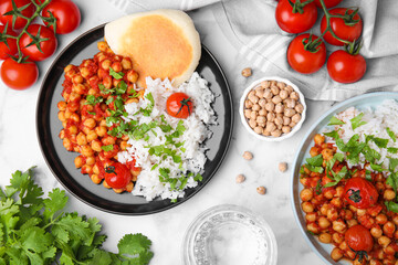 Delicious chickpea curry with rice served on white marble table, flat lay