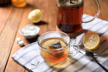 Tea bag in glass cup on wooden table