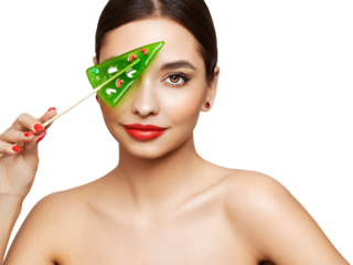Beauty model girl eating Christmas tree shape lollipop.  Beautiful young woman with clean fresh skin. Girl beauty face care. Facial treatment. Cosmetology, beauty and spa. Red nails manicure