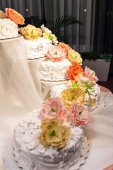 multi-tiered wedding cake decorated with flowers and beads in the banquet hall