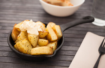 golden fried potatoes with mayonnaise on small cast iron skillet