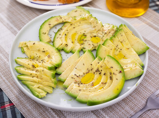 ripe avocado pulp cut into pieces sprinkled with lemon juice on a plate