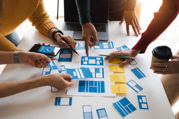 Working at desk, start up, UX team works from a single location under a UX leader and UX managers,...