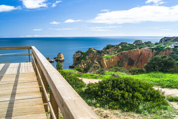 wooden tourist footbridges on the cliffs of Cabo de Sao Vicente. View of beaches, cliffs and ocean. Daylight, horizontal