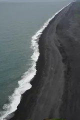 Crédence de cuisine en verre imprimé Eau Ocean with white foamy waves splashing into the black beach