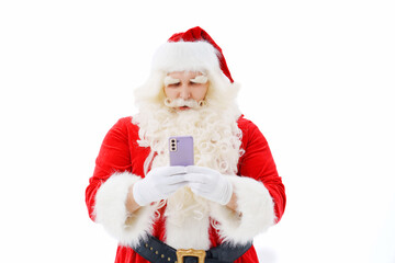 Santa Claus is surprised with a smartphone in his hands on a white background. 