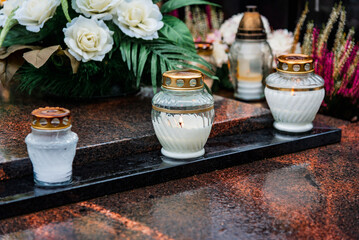 All Saints' Day and burning candles and flowers on the graves.Candles on graves symbolize the memory of the dead on November 1.Catholic cemetery during All Saints' Day.Selective focus.