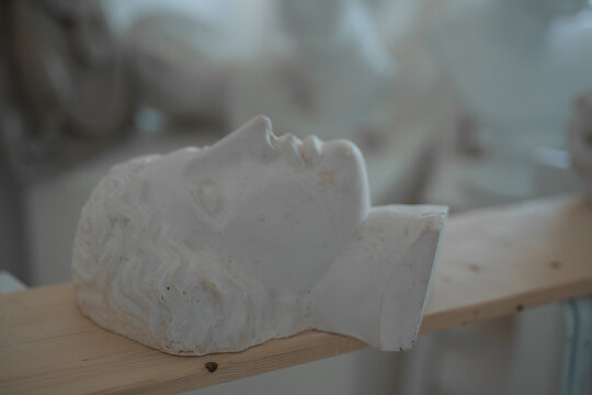 Photo of handcrafted female marble head on board in professional art studio.