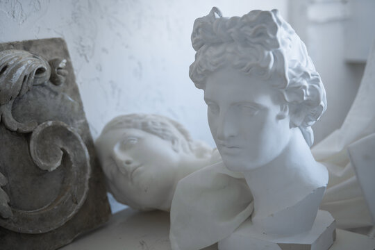 Photo of handmade marble heads of greek people in workshop of sculptor.