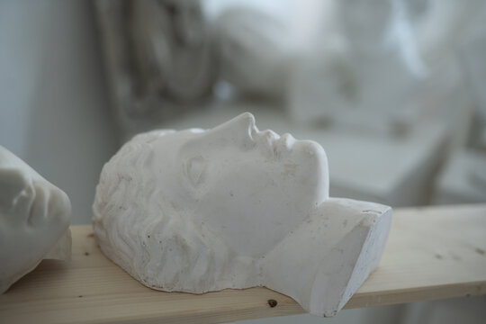 Photo of handcrafted marble heads on board in professional art studio.