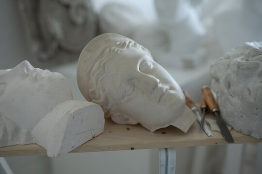 Shot of handcrafted marble busts of greek people and stacks in art studio.